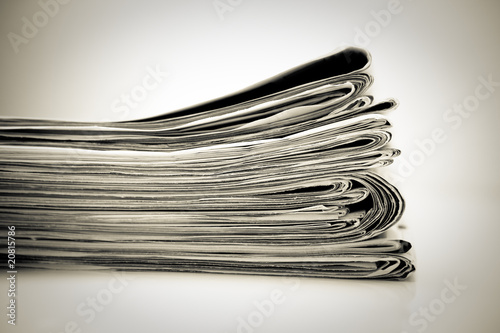 Stapel Zeitungen auf Holztisch, monochrom