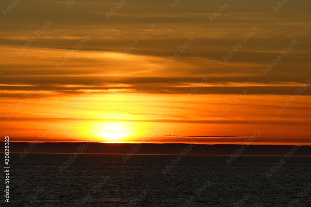 Sunset behind clouds with yellow-red sky
