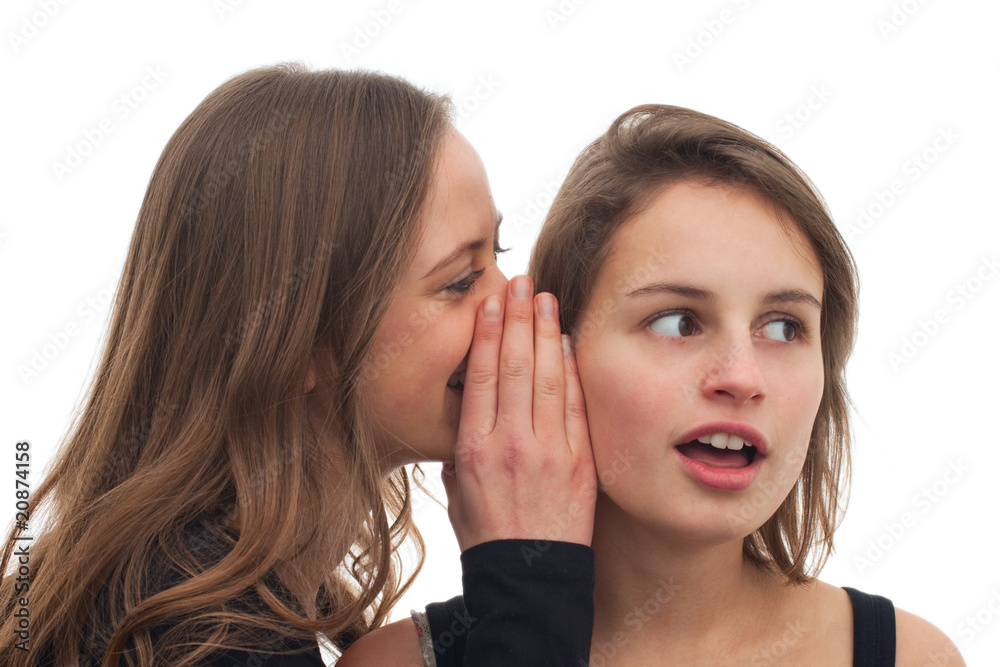 Teenage girl whispering a secret to her friend Teenage girl whispering a secret to her friend