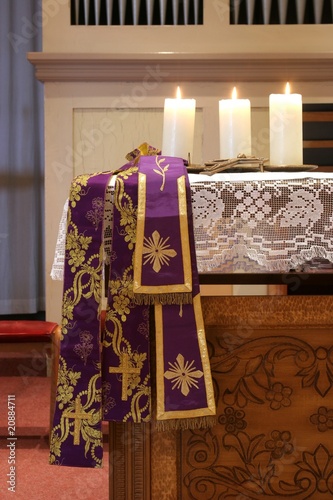 Three burning candles on church altar