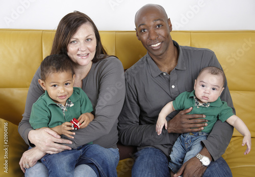 Mixed race young family seated