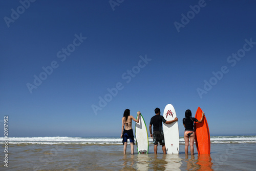 groupe d'amis à la mer avec planches de surf