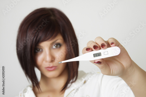 Attractive Caucasian female checking her temperature using a dig