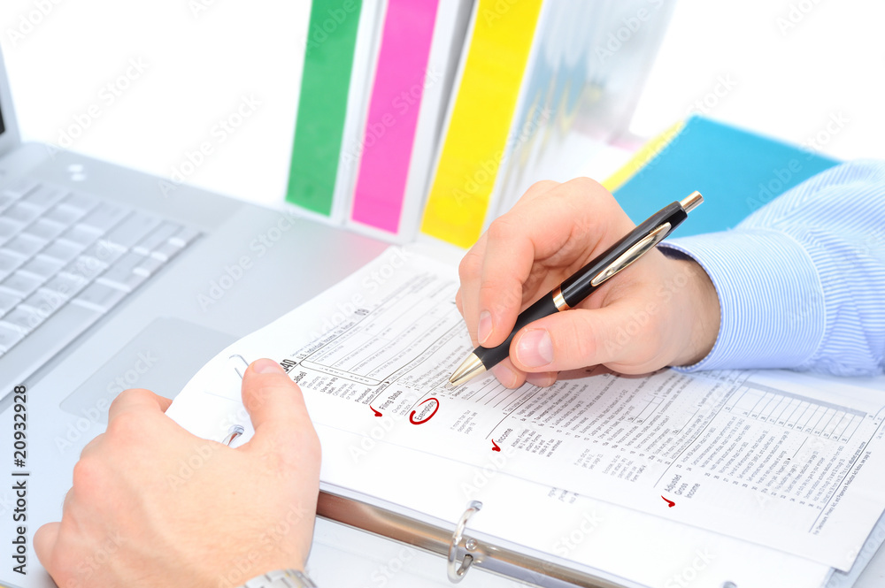Businessman is filling out the tax form Businessman is filling out the tax form