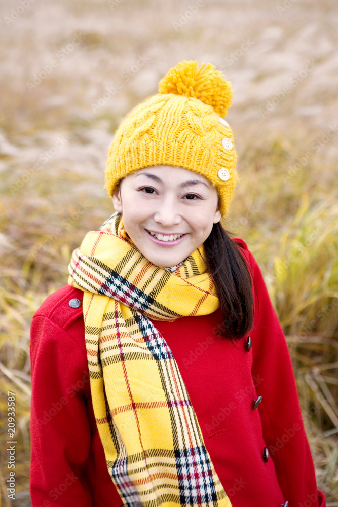 すすき草原の前に立つ女性