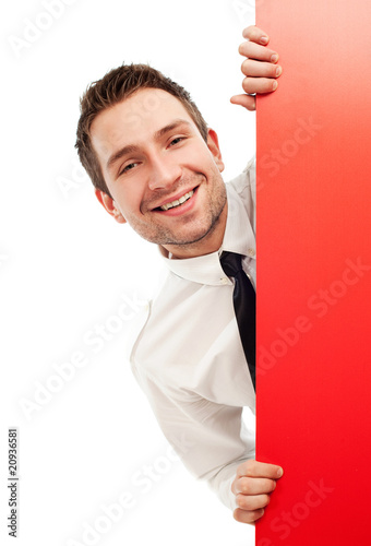 Curious businessman behind red sign