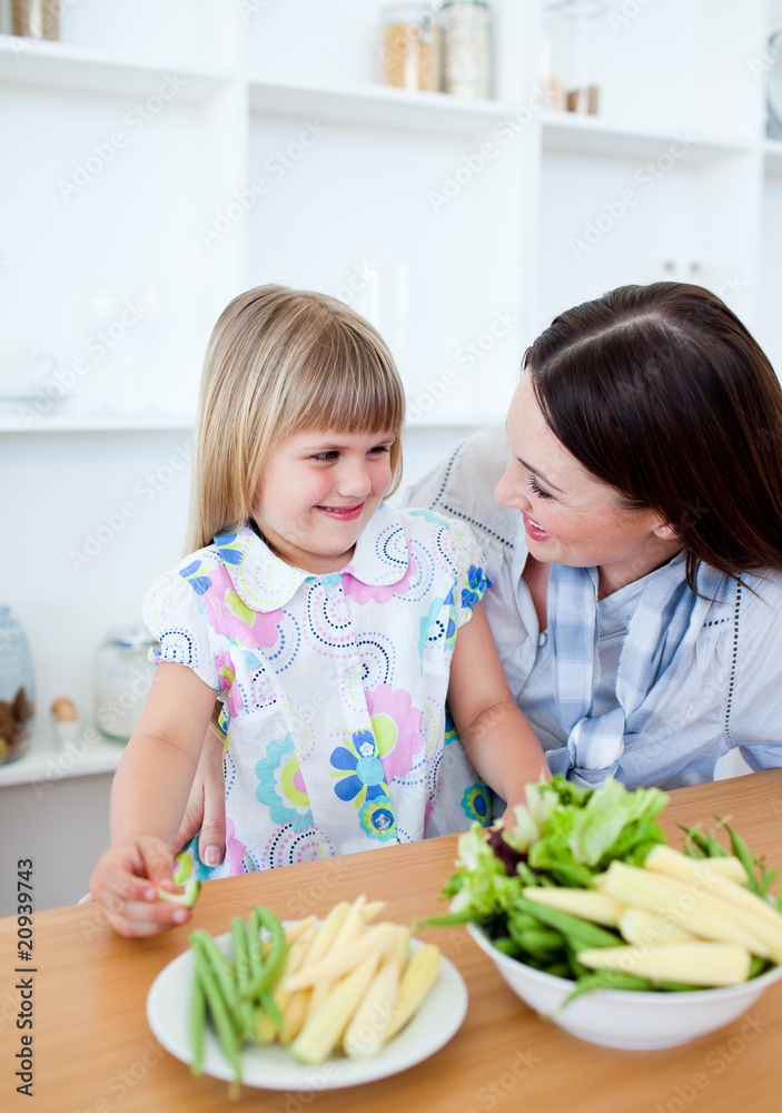 Attentive mother and her daughter eating vegetables Attentive mother and her daughter eating vegetables