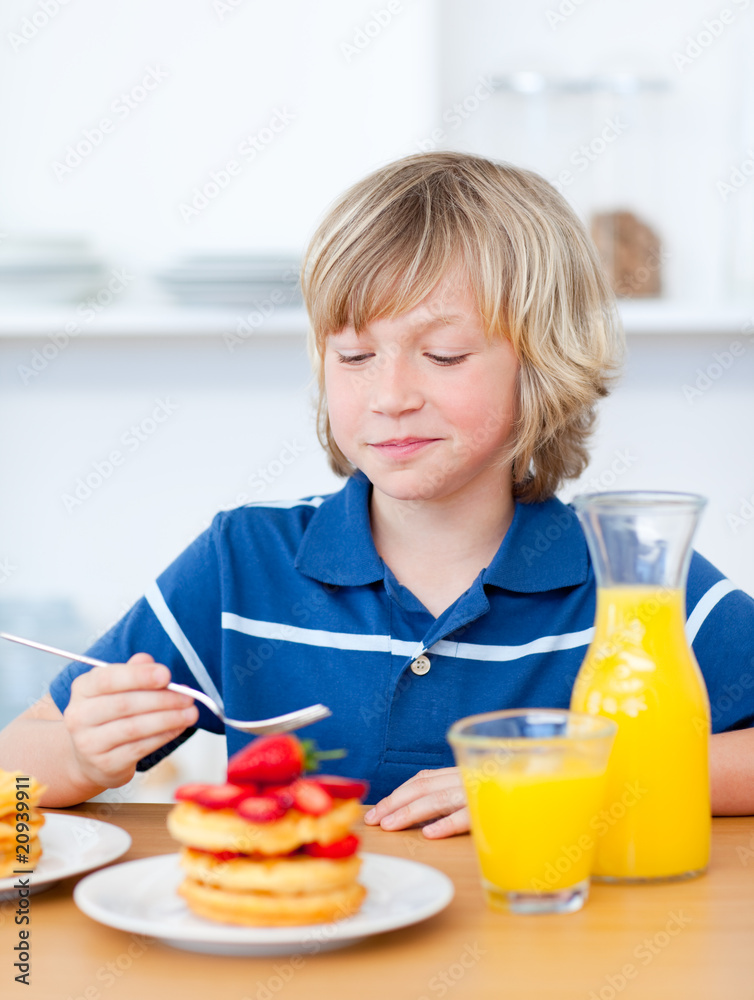 Cute boy eating waffles with strawberries Cute boy eating waffles with strawberries