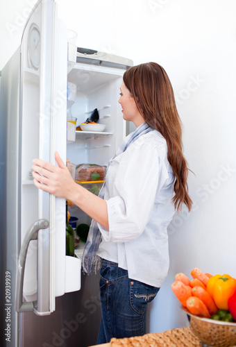 Attractive woman looking for something in the fridge
