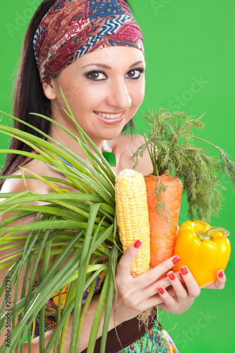 Pretty girl with vegetables on the green background photo