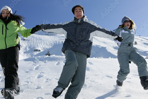 Groupe d'amis courant dans la neige photo