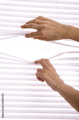 hands apart on the window blinds.
