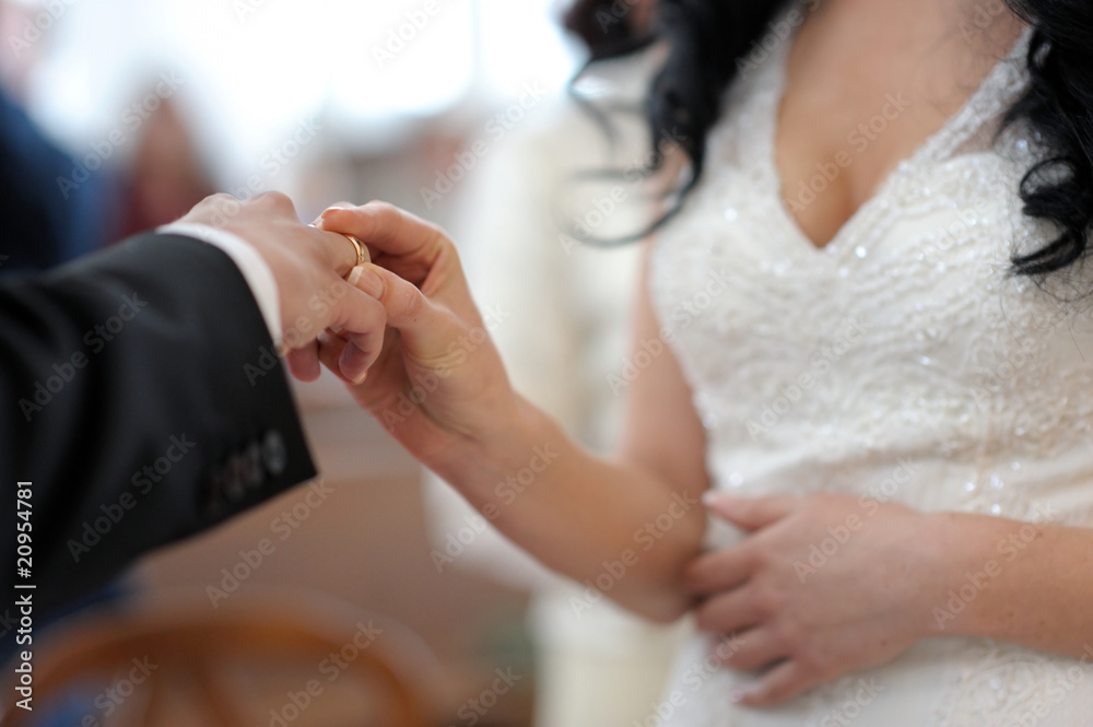 Bride putting the ring on groom's finger Bride putting the ring on groom's finger