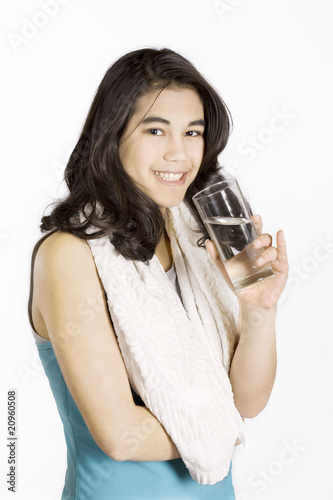 Teenage girl drinking water while exercising