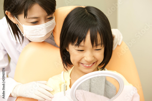 鏡で治療後の確認する女性歯科医と女の子