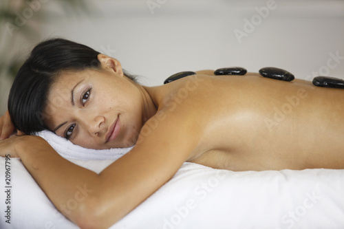 Portrait d'une femme souriante allongée se faisant masser le dos