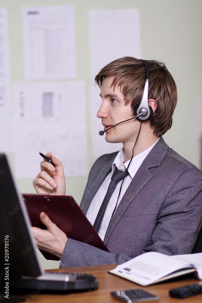 A friendly telephone operator in an office environment. A friendly telephone operator in an office environment.