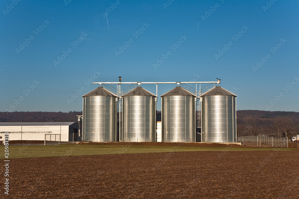 beautiful landscape with silo and snow white acre with blue sky