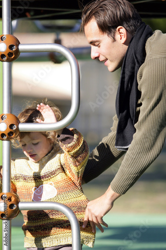Portrait d'une petite fille dans un aire de jeux avec un homme © auremar
