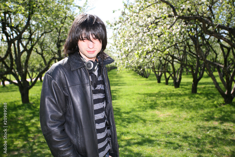young man standing in a flowering spring garden young man standing in a flowering spring garden