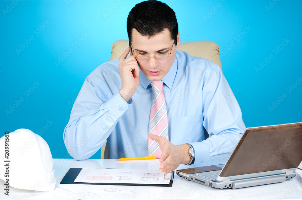 engineer talking on his mobile phone on blue engineer talking on his mobile phone on blue