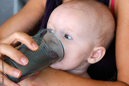 Bébé apprenant à boire au verre.