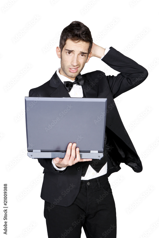Young man in tuxedo looking confused and holding laptop Young man in tuxedo looking confused and holding laptop