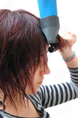 Chica secandose el pelo y peinandose photo