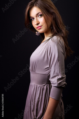 Fashionable elegant girl posing over dark background