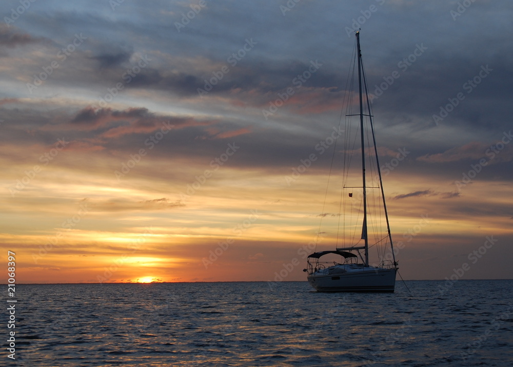 Sailboat Silhouette in Tropical Waters at Sunset