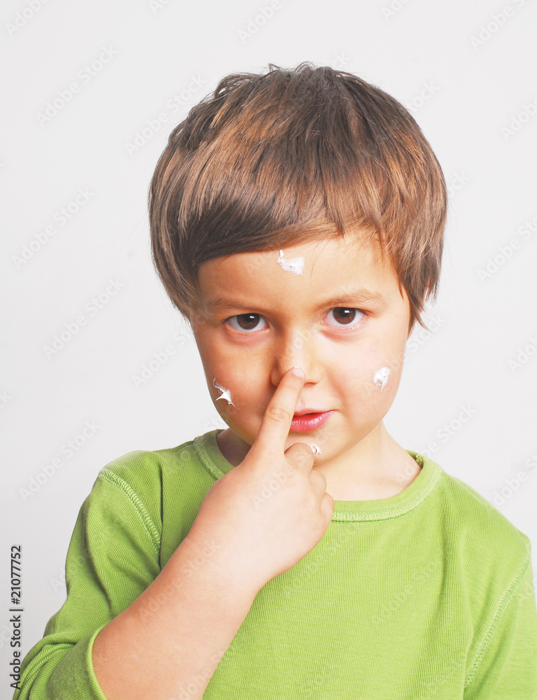 Junge cremt sich das Gesicht ein Junge cremt sich das Gesicht ein