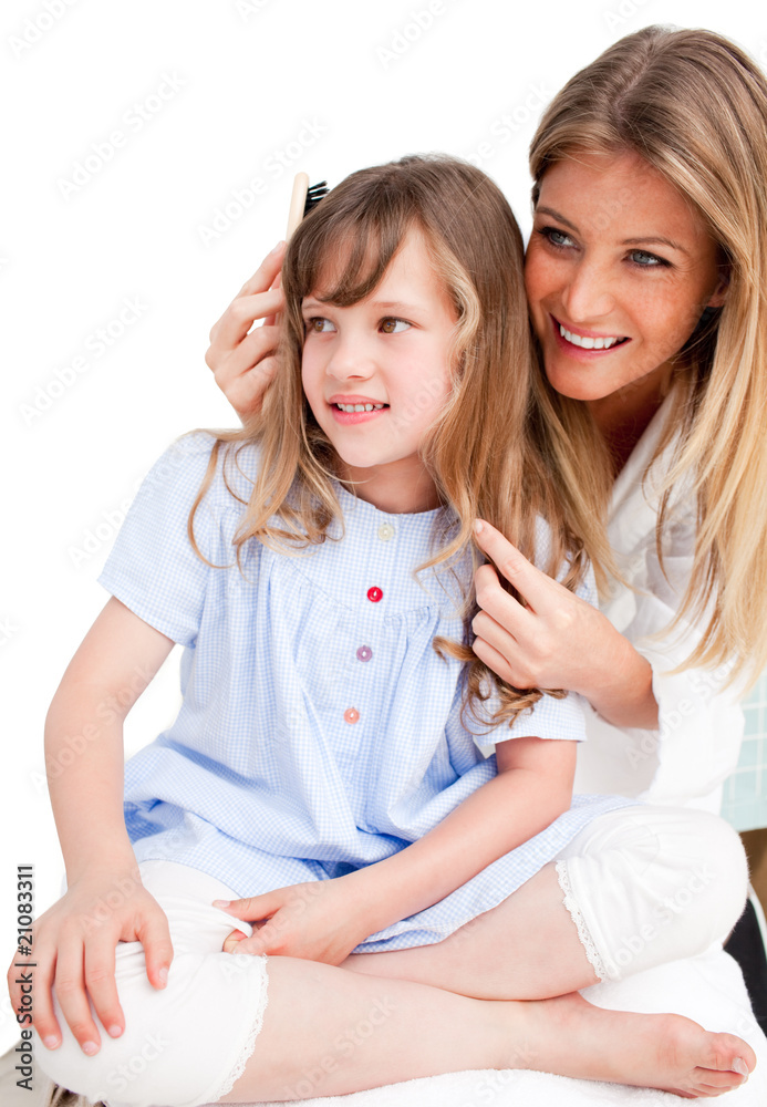 Charming woman brushing her daugther's hair Charming woman brushing her daugther's hair