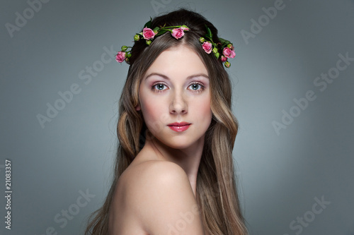 beautiful young woman with garland from small roses