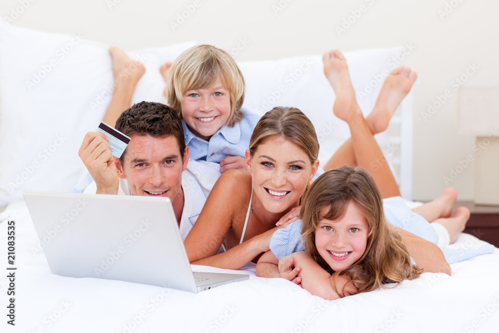 Enthusiastic family buying online lying down on bed Enthusiastic family buying online lying down on bed