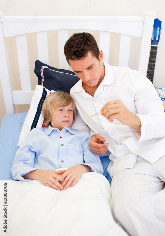 Fototapeta premium Attractive father checking his son's temperature