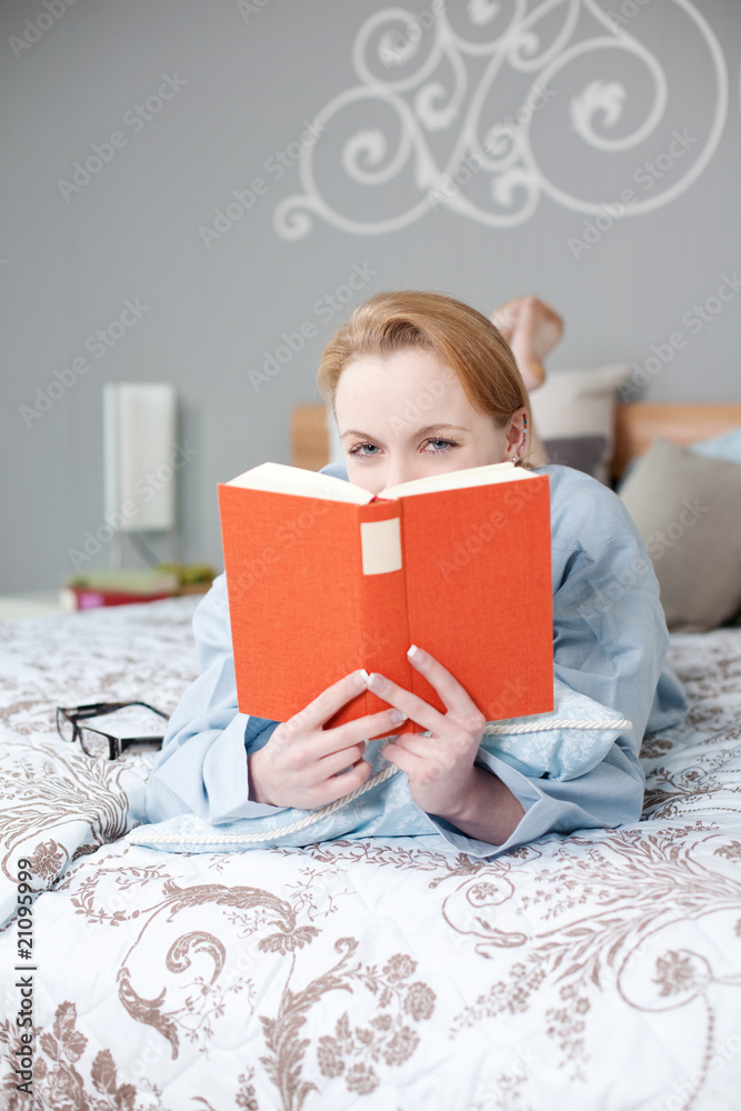 junge frau liest im bett ein buch junge frau liest im bett ein buch