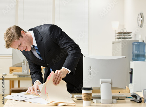 Canvas-taulu Businessman looking through file folders
