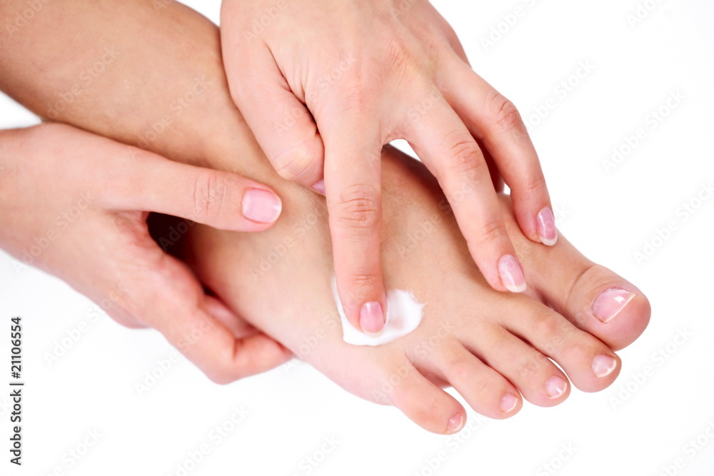 Young woman applies cream on her foot