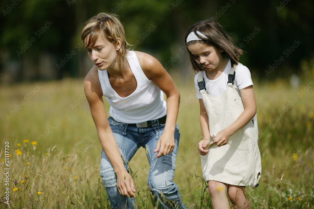 Mère et fille cueillant des fleurs à la campagne Mère et fille cueillant des fleurs à la campagne