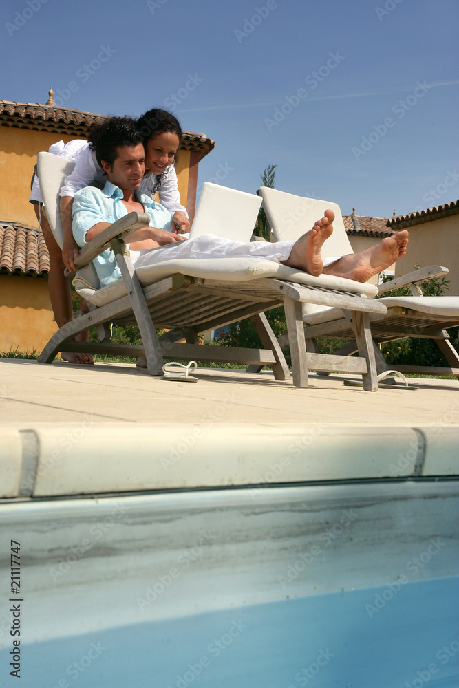 Jeune couple au bord de la piscine
