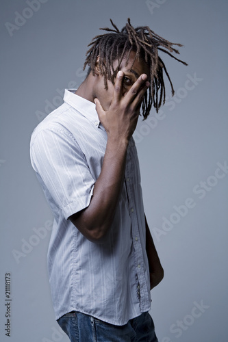 Canvas-taulu Young African American man with dreadlocks covering face