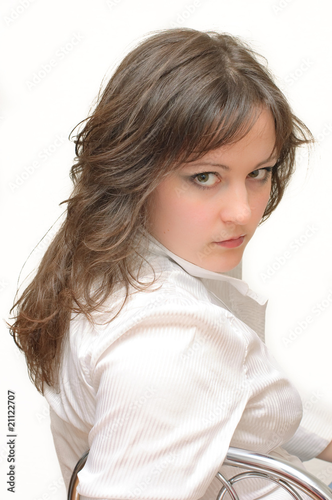 A beautiful young brunette in white shirt looking seriously A beautiful young brunette in white shirt looking seriously