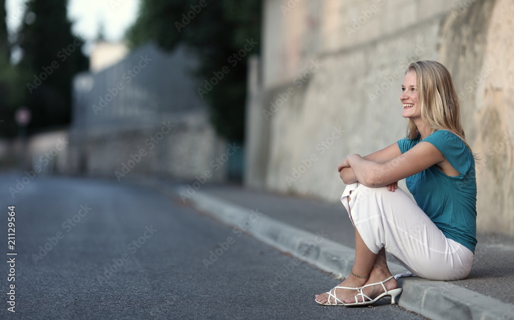 Very pretty young woman sitting on the sidewalk. Very pretty young woman sitting on the sidewalk.