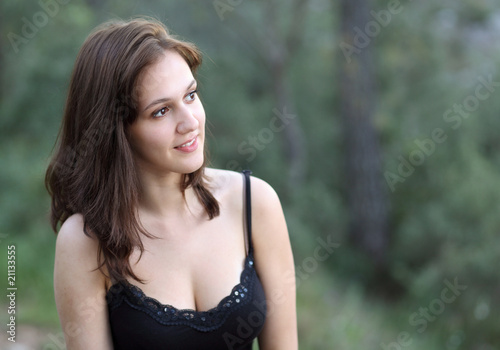Portrait of a very pretty young brunette woman outdoors sitting