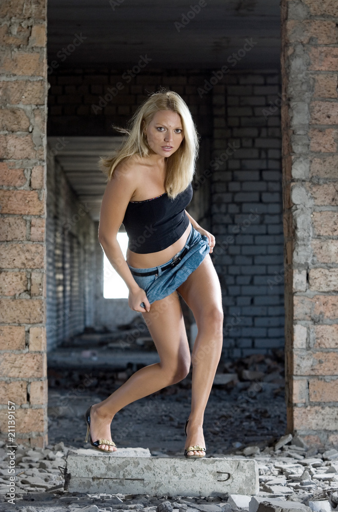 Young beautiful blond woman in abandoned construction