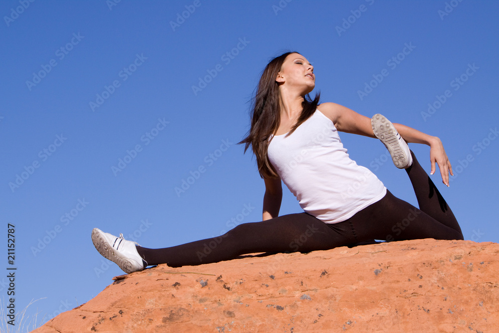 Flexible gymnast girl exercising on red rocks Flexible gymnast girl exercising on red rocks