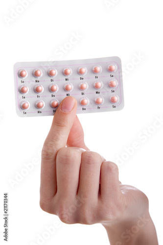 The pill - hand holding contraceptives isolated on white