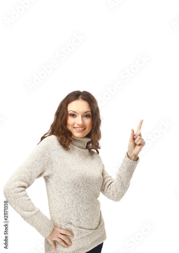 Smiling young woman pointing towards open space