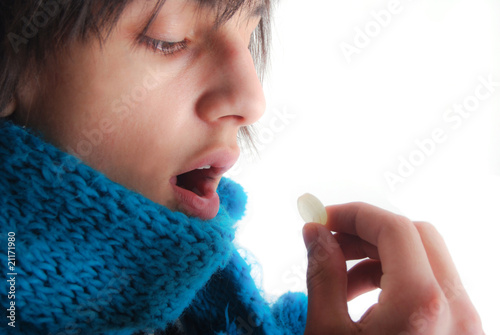 Angine - Adolescent prenant une pastille pour la gorge photo