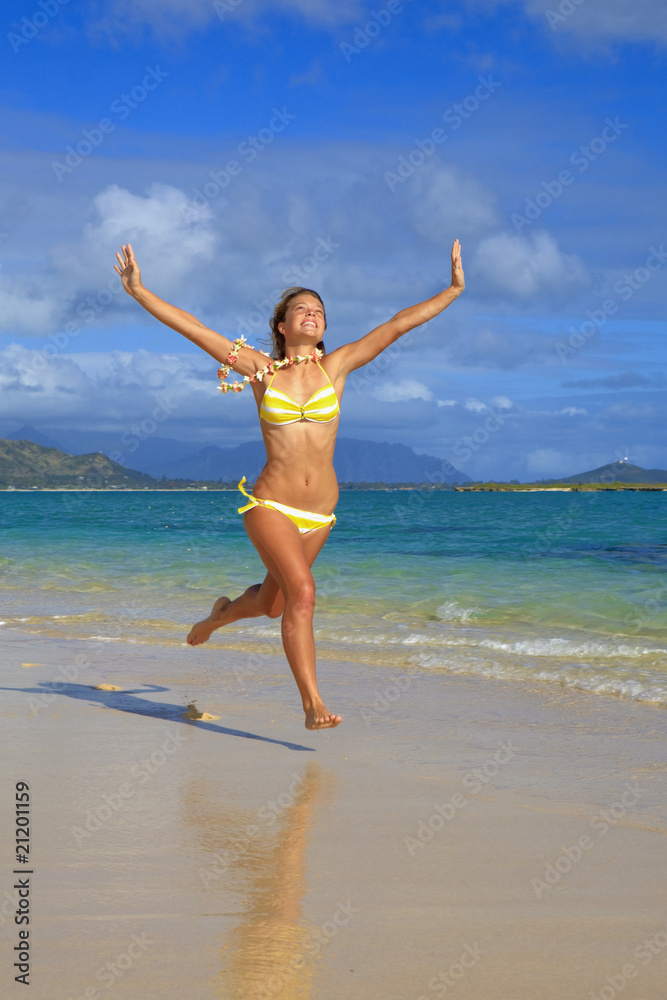 teenage girl runs along the beach at lanikai, hawaii teenage girl runs along the beach at lanikai, hawaii